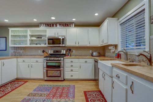 a kitchen with white cabinets and a stove top oven at Northern Lights home in White Salmon