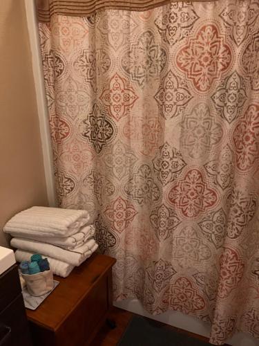 a bathroom with a shower curtain and a pile of towels at Amazing Wood streets studio in Riverside