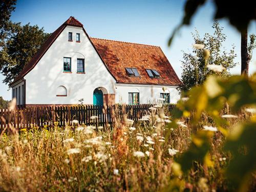 a white house with a red roof and a fence at Stara Szkoła Browina in Browina