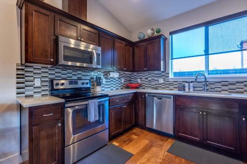 a kitchen with wooden cabinets and stainless steel appliances at Hull Street Loft townhouse in Hood River