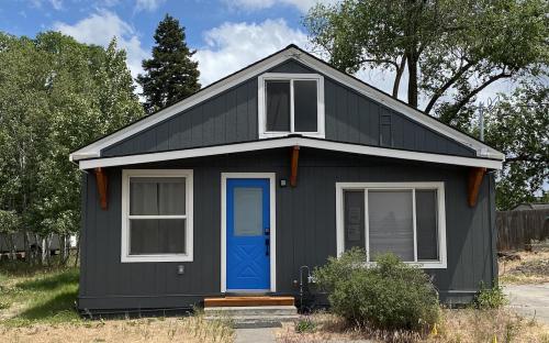 a black tiny house with a blue door at 4th Street Work Friendly Home in Bend