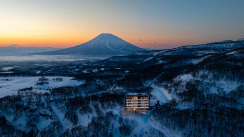 a mountain in the distance with a building in the foreground at Chalet Ivy Weiss, Niseko in Kutchan
