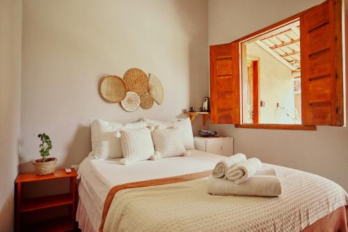 a bedroom with a bed with two towels on it at Vila Três - A apenas 2 minutos da praia! in Caraíva