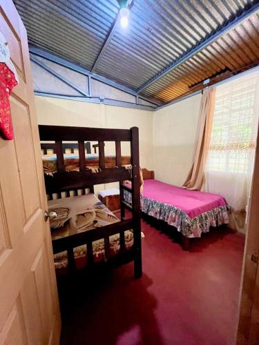 a room with two bunk beds and a window at Starfruit House in Chachagua