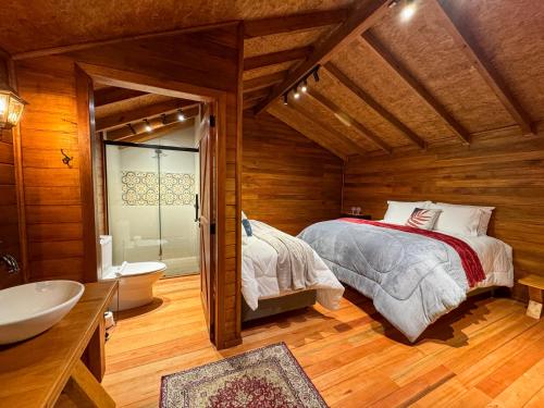 a bedroom with a bed and a tub and a sink at Villa Vida Cabanas in São Joaquim