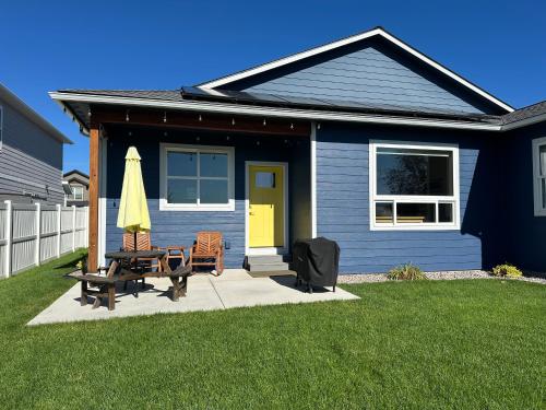 a blue house with a table and a yellow door at Hometown Place in Missoula