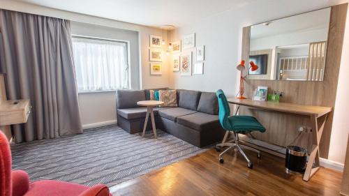 a living room with a couch and a desk at Holiday Inn London-Shepperton by IHG in Shepperton