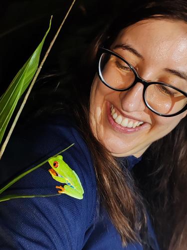 a woman wearing glasses and a green bird on her shoulder at Starfruit House in Chachagua