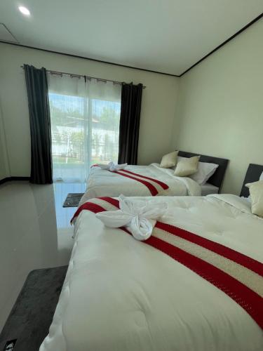 two beds in a room with a window at 3P Phuket Airport Hotel in Phuket