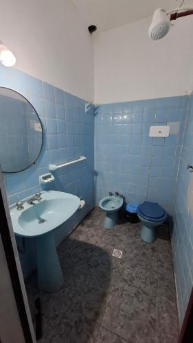un bagno piastrellato blu con lavandino e WC di Hospedaje Artigas a Corrientes