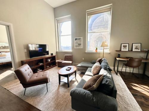 un soggiorno con un divano e una TV di Downtown Sleek 2BR Loft a Milwaukee