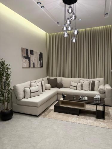 Una sala de estar con un sofá y una mesa de café. en Lilian Home, en Yeda