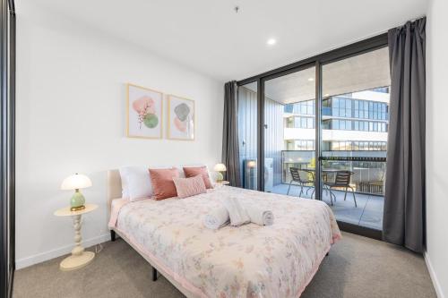a bedroom with a bed and a balcony at Stylish Woden Apt Near Hospital w Pool, Parking in Phillip