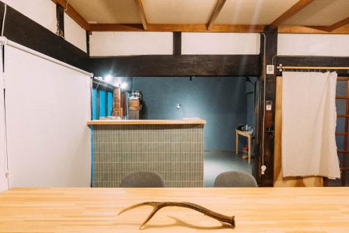 a wooden table in a room with a bar at hinatabocco guesthouse kominka Twin room bed in Miyaki