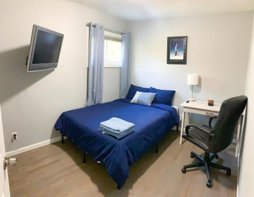 a bedroom with a blue bed and a desk and a chair at Davids Family Home in Bay Shore