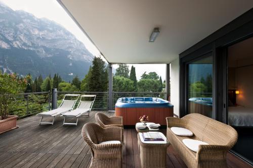 a room with a deck with a tub and chairs at Du Lac Et Du Parc Grand Resort in Riva del Garda