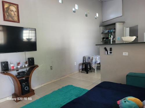 a living room with a flat screen tv on the wall at Unidades 1 e 2 e 3 Pousada do Sossego Mar e Verde in Itanhaém