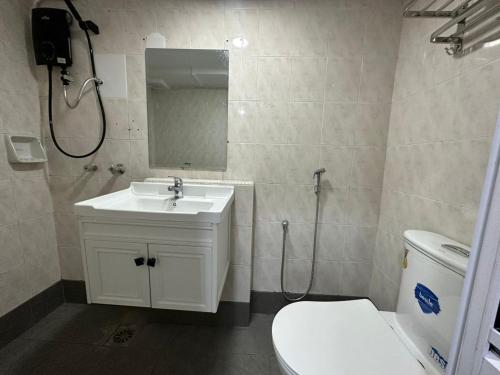 a bathroom with a sink and a toilet and a mirror at SS Grey Hotel BBKL in Kuala Lumpur