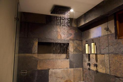 a bathroom with a shower with water on the wall at TsiaBie Hotel in Choachí