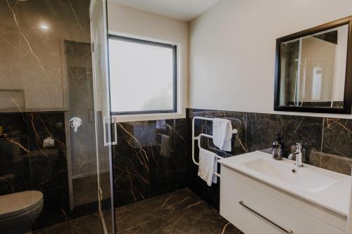a bathroom with a sink and a shower at Ocean & Mountain Views - Kaikoura in Kaikoura