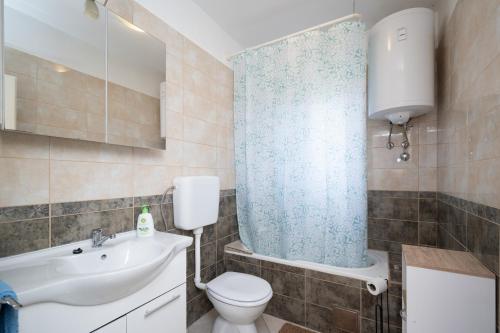 a bathroom with a toilet and a sink and a shower at Apartments with parking space Palit, Rab - 22676 in Rab