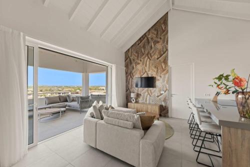 a living room with a couch and a dining room at Penthouse Blue View - Aquamarine 10 in Sint Michiel