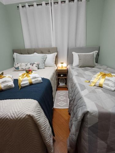 two beds sitting next to each other in a room at Casa no Centro de Pomerode - Pousada in Pomerode