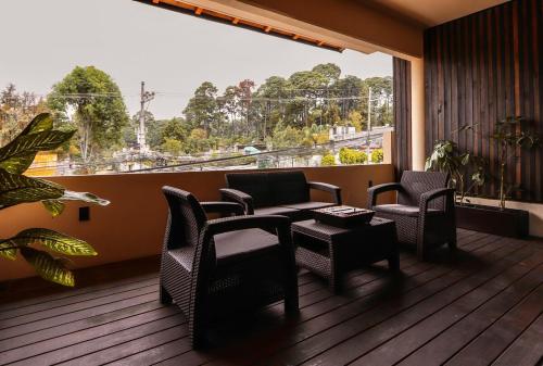 a balcony with chairs and a table and a window at Bonito departamento en Avandaro in Valle de Bravo