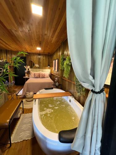 eine Badewanne mit Vorhang in einem Zimmer in der Unterkunft Casa das Palmeiras in Orleans