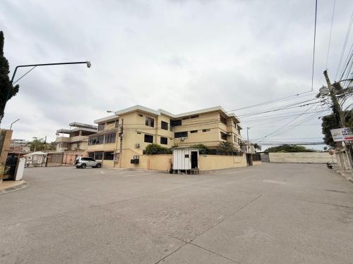 an empty parking lot in front of a building at Sol y Confort Suites in Machala