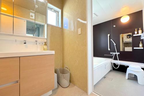 a bathroom with a tub and a sink and a toilet at グランディオーソ沖縄ヴィラ恩納3 in Onna
