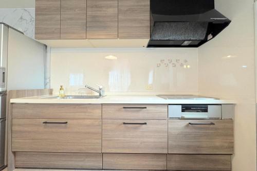 a kitchen with wooden cabinets and a sink at グランディオーソ沖縄ヴィラ恩納3 in Onna