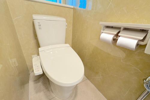 a bathroom with a toilet and two rolls of toilet paper at グランディオーソ沖縄ヴィラ恩納3 in Onna
