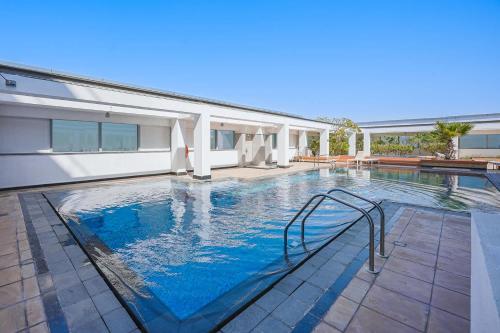 a swimming pool with blue water in front of a building at Free housekeeping visits during your stay - StayShort - Extravagant Studio in DIFC with Skyline Views in Dubai