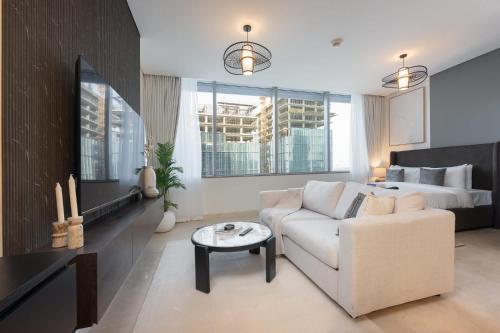 a living room with a couch and a bed at Free housekeeping visits during your stay - StayShort - Extravagant Studio in DIFC with Skyline Views in Dubai