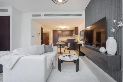 a living room with a white couch and a table at Free housekeeping visits during your stay - StayShort - Extravagant Studio in DIFC with Skyline Views in Dubai