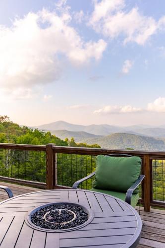 a table and chairs on a deck with a view at Above and Beyond in Boone