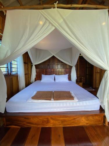 a bedroom with a white bed with a canopy at Lily's Blue View in Koh Rong