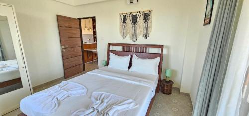 a bedroom with a bed with white sheets and pillows at Elegant 1BHK Couples Getaway with River View, Pool, Gym, Amenities - Near Candolim Beach in Candolim