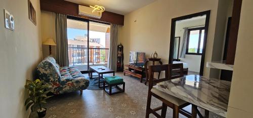 a living room with a couch and a chair and a table at Elegant 1BHK Couples Getaway with River View, Pool, Gym, Amenities - Near Candolim Beach in Candolim