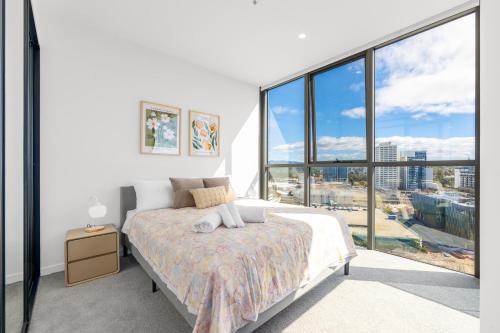 a white bedroom with a bed and large windows at Sunny Central Woden Apt,Hospital, CIT , Pool in Phillip