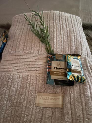 a bed with a blanket with a packet of cigarettes and a plant at CABANA SERRA DA BALANÇA in Gonçalves