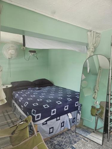 una camera da letto con un letto e uno specchio di Bed & Shower Stop a East End