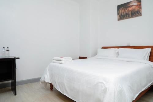 a bedroom with a large bed with white sheets at Modern Guest House 2BR in Nakuru