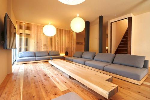 a living room with a blue couch and a wooden table at 水縹日光 in Nikko