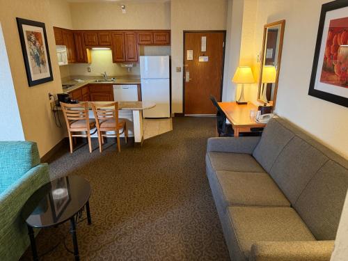 a living room with a couch and a table and a kitchen at McAllen Plaza Hotel and Suites in McAllen