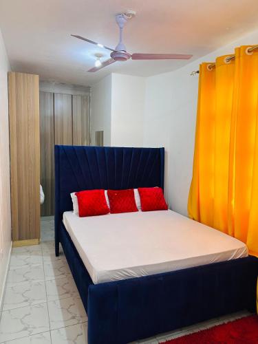 モンバサにあるHome by Mercy Apiyoの赤い枕2つが付いたベッド1台