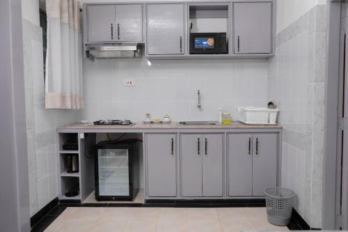 a kitchen with white cabinets and a counter top at Modern Guest House 2BR in Nakuru