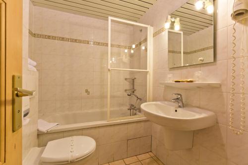 uma casa de banho com um lavatório, um WC e um chuveiro em Hotel La Montagne em La Clusaz