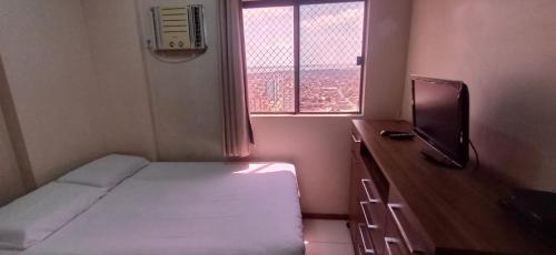 a small bedroom with a bed and a window at Excelente apartamento a 5 min da COP30 in Belém